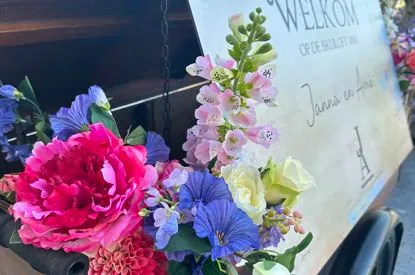 Bloemen bij het welkomstbord van een bruiloft